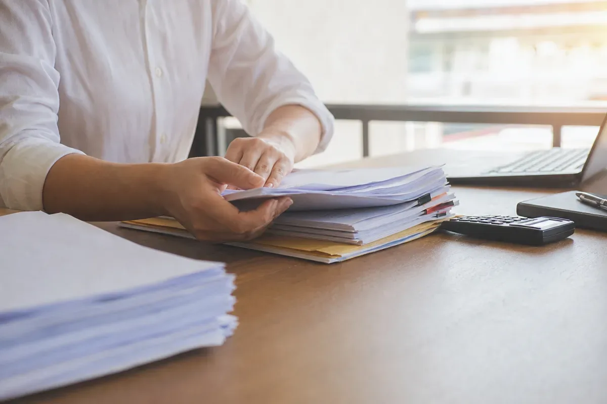 Người mua đối chiếu hồ sơ nhà đất trên bàn làm việc