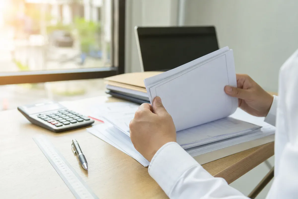Phối cảnh minh hoạ người mua đối chiếu giấy chứng nhận căn hộ tại bàn làm việc