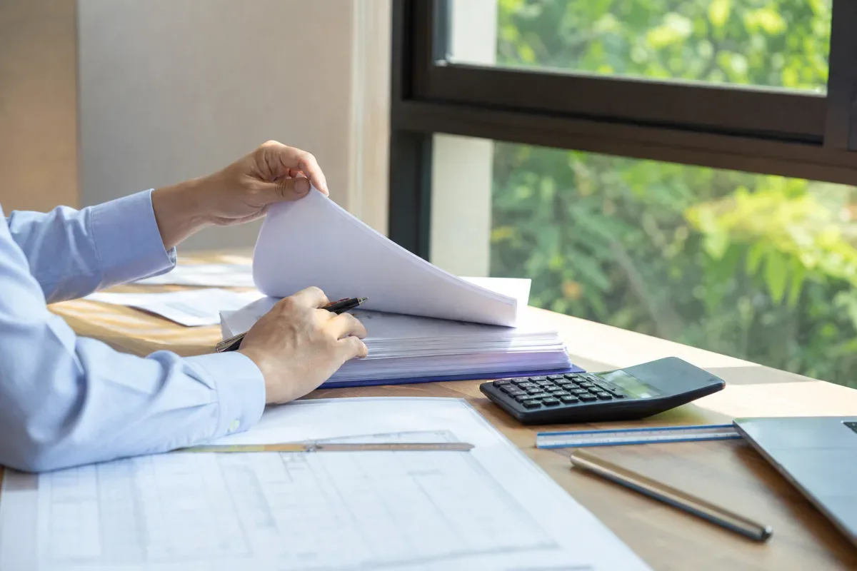 Người mua đối chiếu hồ sơ dự án nhà ở tại bàn làm việc